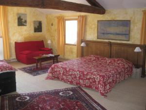 - une chambre avec un lit rouge et un canapé rouge dans l'établissement Gîte Aux Tournesols, à Malaucène