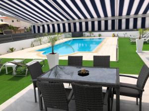 a patio with a table and chairs and a swimming pool at Kypkeys Apartments in Voroklini