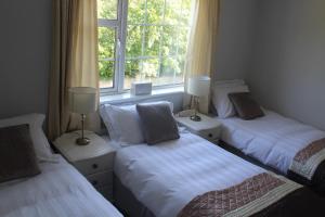 three beds in a room with a window at 5 mins walk to Carrick - Sleeps 12 - Off road parking - Modern house in Carrick on Shannon