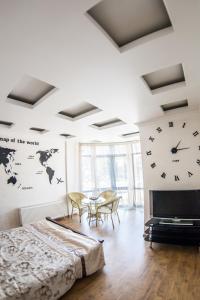 a bedroom with a clock on the wall and a table at Fresh Arcadia Apartments in Odesa