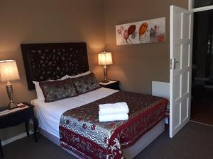 a hotel room with a bed and two lamps at The Yardt Guest House in Trichardt +26 photos