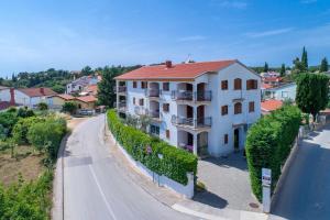 une grande maison blanche sur le côté d'une route dans l'établissement Apartments Villa Tre Marie, à Rovinj