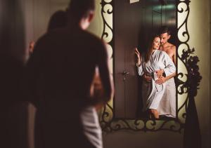 
a man and a woman standing in front of a mirror at Terme Olimia - Hotel Sotelia in Podčetrtek
