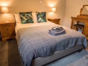 ein Schlafzimmer mit einem Bett mit zwei Nachttischen und zwei Lampen in der Unterkunft The Birches in Dingwall