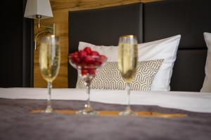 two glasses of champagne and a vase of roses on a table at Aurum hotel in Bishkek