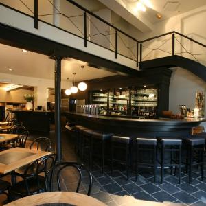 restauracja ze stołami i krzesłami oraz bar w obiekcie Hotel De Groene Hendrickx w mieście Hasselt