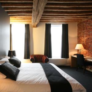 a hotel room with a large bed and windows at Hotel De Groene Hendrickx in Hasselt