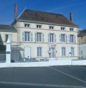 una gran casa blanca con una valla blanca en L'ancienne École, en Geay