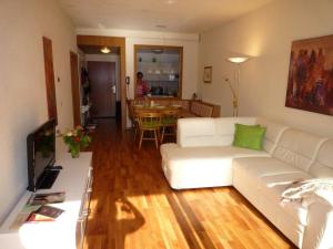 a living room with a white couch and a table at Seewohnung am Ossiacher See direkt an der Gerlitzen in Villach