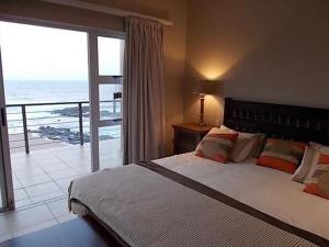 um quarto com uma cama e vista para o oceano em Tinley Manor Beachfront KSV1 em Ballito