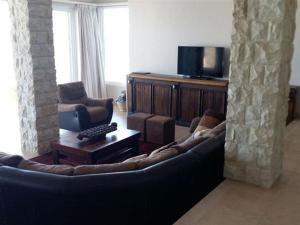 a living room with a couch and a tv at Tinley Manor Beachfront KSV1 in Ballito