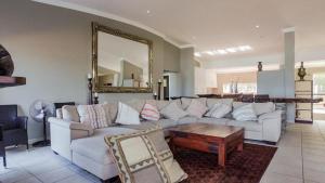 a living room with a white couch and a mirror at Tinley Manor Beachfront KSV1 in Ballito