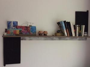 a shelf with books and other items on a wall at belle la vie in La Plaine des Cafres