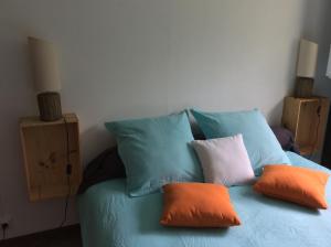 a blue bed with four pillows on it at belle la vie in La Plaine des Cafres
