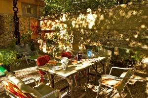 eine Terrasse mit einem Tisch, Stühlen und einer Ziegelwand in der Unterkunft Le Quinquerlet in Apt