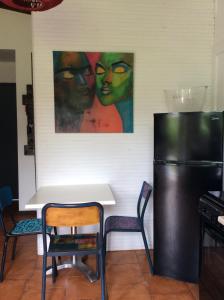a table and chairs in a kitchen with a painting on the wall at lesept in La Plaine des Cafres