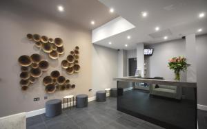 a lobby with a bunch of disks on the wall at Trebovir Hotel in London