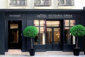 two potted trees in front of a hotel viceroy opera at Victoires Opera in Paris