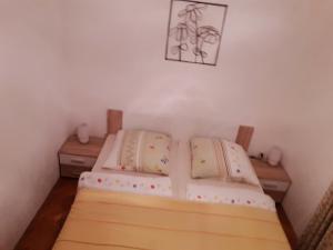 two twin beds in a room with two tables at Apartment Bjanka in Pakoštane
