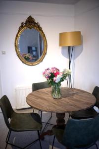 uma mesa com um vaso de flores e um espelho em Cozy Pijp Apartment Amsterdam em Amesterdão