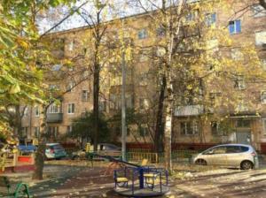 un parque infantil frente a un gran edificio de ladrillo en City Inn Apartment Sokolniki, en Moscú