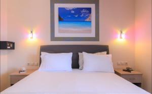 a bedroom with a bed with white sheets and two lights at Das Maistrali 1 in Sarti