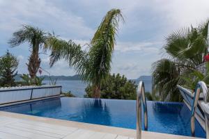 ein Schwimmbecken mit Blick auf das Wasser in der Unterkunft Nur Beach Hotel in Kaş