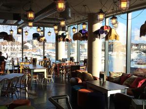 a restaurant with tables and chairs and a view of a harbor at Waterside House in Southampton +15 photos