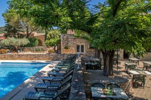 une rangée de tables et de chaises à côté d'une piscine dans l'établissement L'Escarbille, à Saint-Martin-dʼArdèche