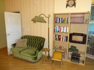 a living room with a green couch and a book shelf at le mignon in Illingen