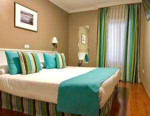 Een bed of bedden in een kamer bij Hotel Spa La Quinta Park Suites
