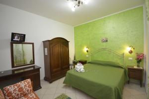 サン・ヴィート・ロ・カーポにあるtre passi dal mareのベッドルーム1室(緑のベッド1台、テディベア付)