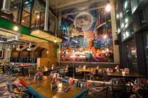 a restaurant with tables and chairs and a large mural at Waterside House in Southampton