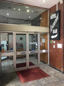 a lobby with doors and a bar sign in a building at Firmhotel le 37 in Firminy