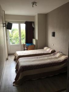 een hotelkamer met 3 bedden en een raam bij Firmhotel le 37 in Firminy