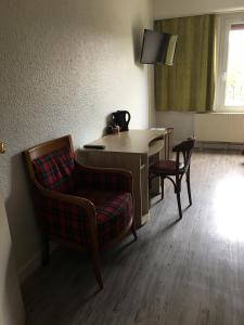 een kamer met een bureau, een stoel en een tafel bij Firmhotel le 37 in Firminy