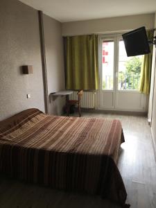 a hotel room with a bed and a large window at Firmhotel le 37 in Firminy