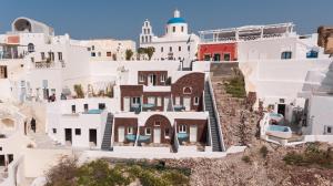 a house on a hill with white buildings at Secret Legend Suites in Oia
