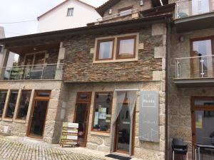 een winkel voor een bakstenen gebouw met ramen bij Recantos da Estrela in Sabugueiro