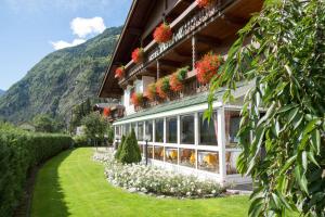 ein Gebäude mit Blumen auf der Seite in der Unterkunft Hotel Mirabell in Sand in Taufers