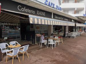 a man sitting at a table outside of a restaurant at Hotel Xaine Park in Lloret de Mar