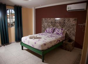 a bedroom with a bed with purple sheets at Residencial Turistico Cuba in Panama City