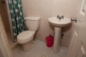a bathroom with a toilet and a sink at Residencial Turistico Cuba in Panama City