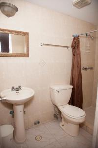 a bathroom with a toilet and a sink at Residencial Turistico Cuba in Panama City