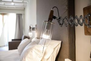 a bedroom with a bed and a lamp on the wall at Rigas Boutique Hotel & Spa in Afitos
