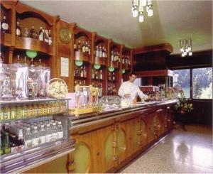 a man standing behind a counter in a bar at Hotel Residence La Rosa in Castione della Presolana