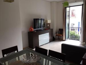 a living room with a television and a table and chairs at Apartamento centro Sevilla in Seville