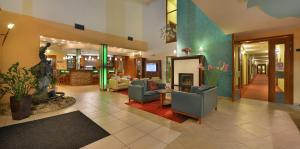 eine Lobby mit Sofas und Stühlen in einem Gebäude in der Unterkunft Wellness Hotel Happy Star in Hnanice