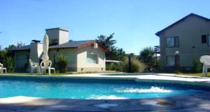 une grande piscine en face d'une maison dans l'établissement Posada El Jarillal, à Sierra de la Ventana