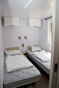 2 Betten in einem Zimmer mit weißen Wänden in der Unterkunft Tornade in Dirbach